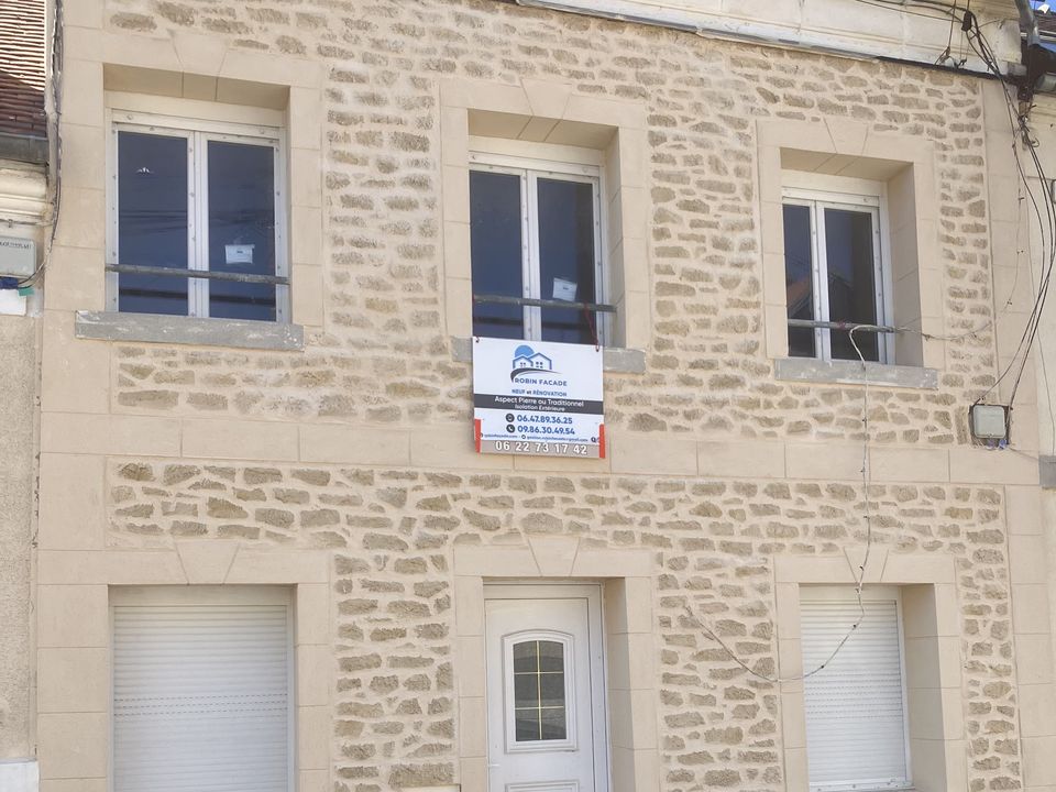 La même maison de ville terminée, façade en enduit aspect pierre appareillée.